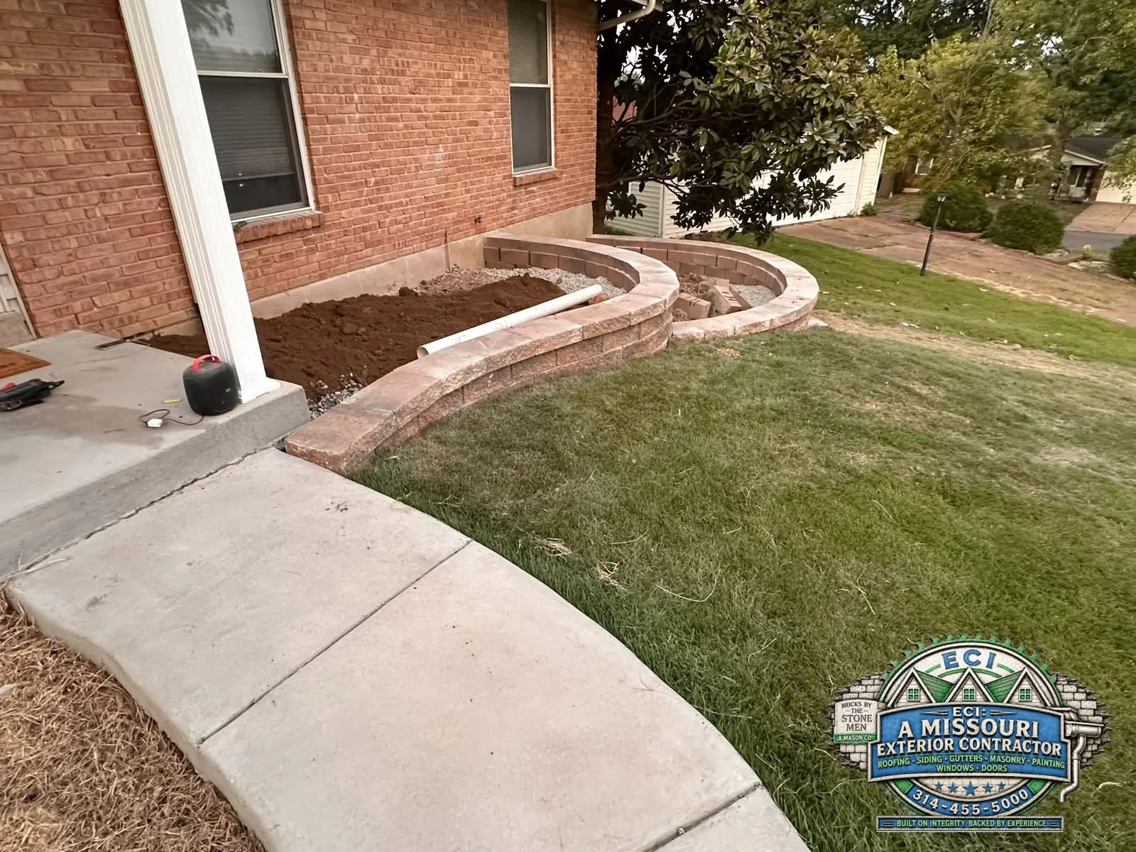 Curved brick retaining wall built by ECI beside a Missouri home