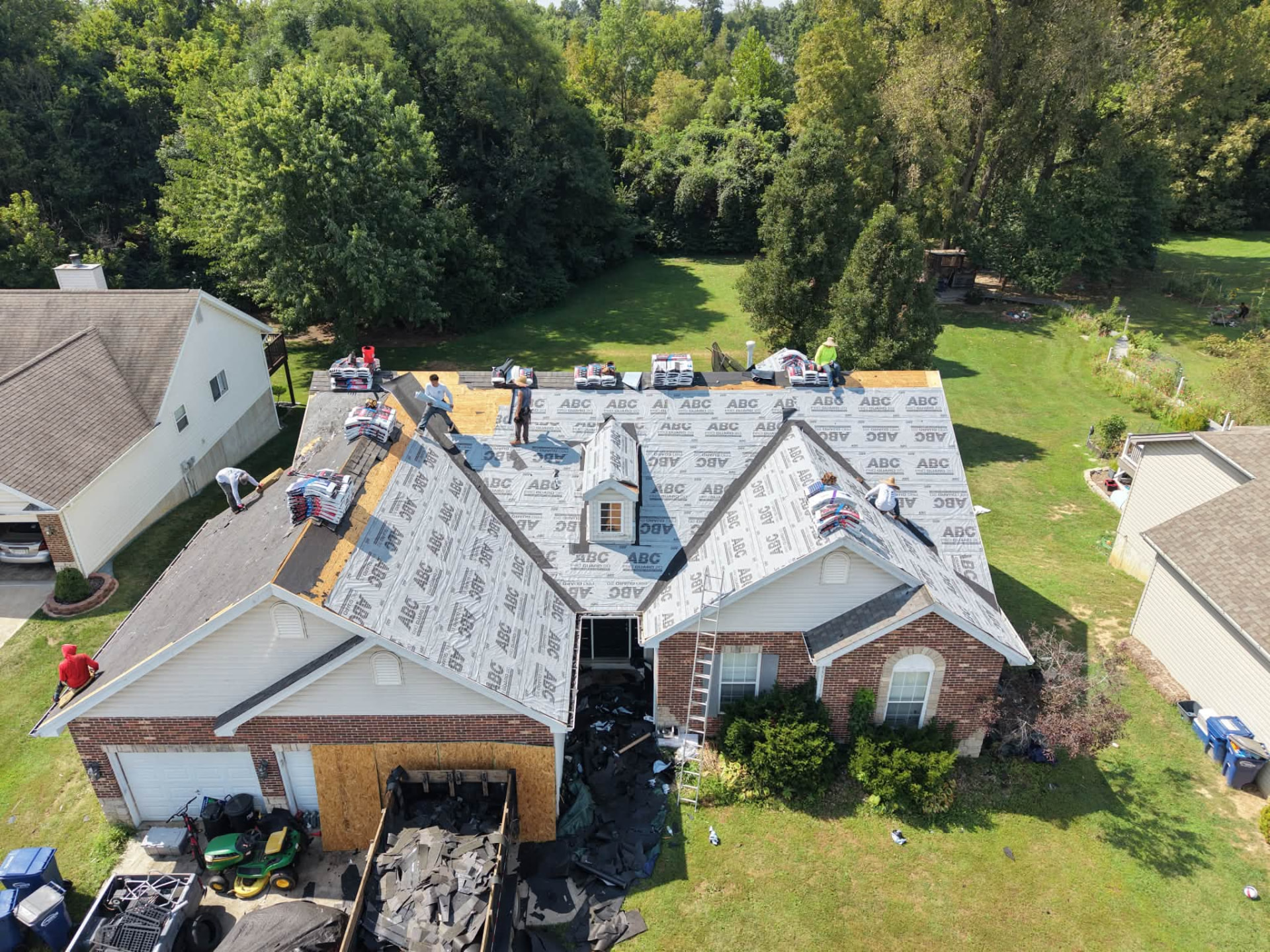 Sunny-day aerial of a full ECI crew on a large roof